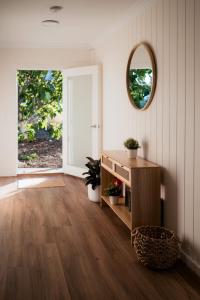 a living room with a wooden floor and a mirror at Central Goolwa- Coastal Family & Friend Retreat in Goolwa