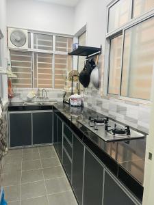 a kitchen with a sink and a stove at StayD'Cassia Homestay Semenyih in Semenyih +1 photo