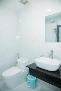 ホーチミン・シティにあるGIA BẢO HOTEL Thủ Đứcの洗面台とトイレを備えた白いバスルーム