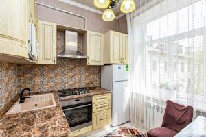 a kitchen with wooden cabinets and a sink and a window at Двухкомнатная евро двушка в самом центре Алматы, 10 минут ходьбы до Арбата #23 in Almaty +20 photos