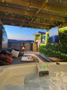 a hot tub on a patio with a tv at Tan Y Bryn Glamping in Conwy