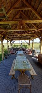 a large wooden table under a large wooden roof at Tanya 360° in Lajosmizse