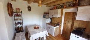 a small kitchen with a white table and a small table with a candle at Tanya 360° in Lajosmizse