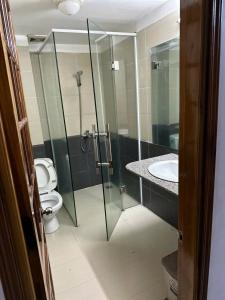 Un baño con ducha de cristal y un inodoro. en Nhà nghỉ THANH HẰNG, en Hue