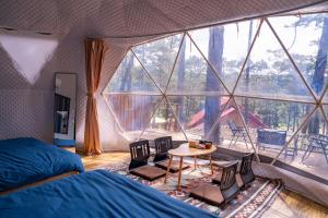 a bedroom with a bed and a table in a tent at De Vivre Café & Home in Kon Plong