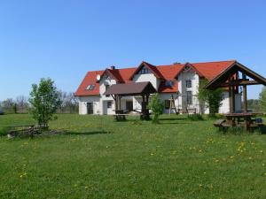 a house with a picnic table in a field at Kalski Dworek in Węgorzewo