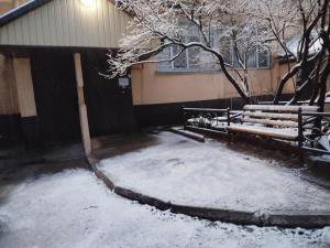 a snow covered bench in front of a building at Квартира in Taraz