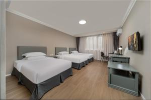 Posteľ alebo postele v izbe v ubytovaní Oak Hotel Chengdu Jiuyanqiao Chuanyin Branch