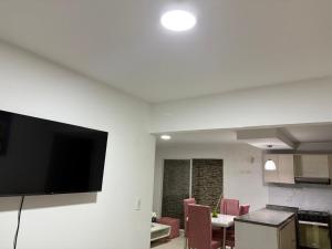 Una cocina y un comedor con TV de pantalla plana. en Casa ciudad jardín, en Barranquilla