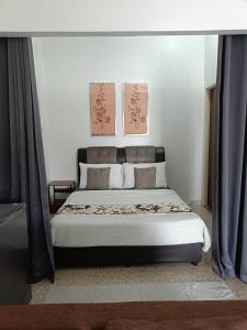 a bedroom with a large bed with blue curtains at Canal Studio Room Kota Bharu in Kota Bharu +22 photos