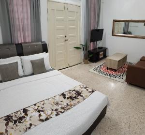 a bedroom with two beds and a mirror and a door at Canal Studio Room Kota Bharu in Kota Bharu