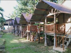 a row of wooden houses are lined up at Palaboy Skatecamp Native House Beach Resort in Daanbantayan