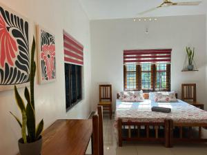 a bedroom with a bed and a table and a window at Tropical Villa in Varkala