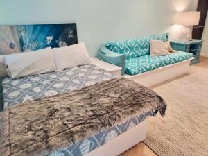 a bedroom with a bed and a couch at Beauty tiny Walk To Sea in Port Douglas +55 photos