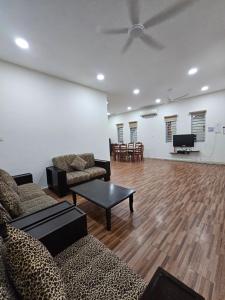 a living room with a couch and a table and a tv at Warni Villa 197 Whole Or Room in Muar