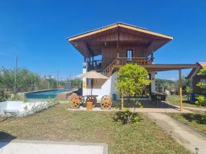a house with a wrap around porch with a deck at Balai Elmienna - solar powered farm house with pool in San Juan