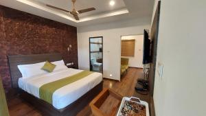 a bedroom with a bed and a television in it at Wild Stories Resort, Munnar in Anachal