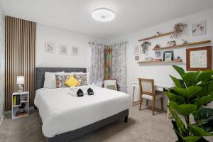 a bedroom with a white bed and a desk at Ocean glimpse from the patio in Pacifica