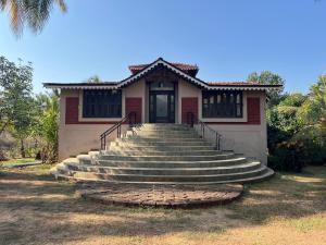 a small house with stairs leading to a door at Konkan Crown Resort & Club in Sawantwadi