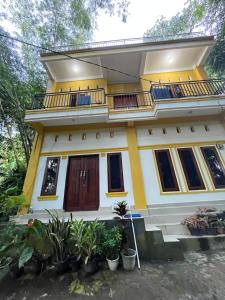 兰特包Bamba Homestay的黄色和白色的房子设有阳台