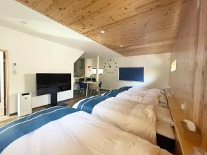 洲本市Famille的一间卧室,配有两张床和一台平板电视