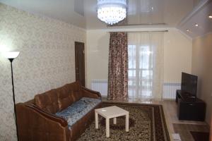 una sala de estar con un sofá y una mesa en Apartments Galactika, en Uralsk