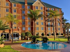 an apartment building with a pool in front of it at ANEW Hotel Centurion Pretoria in Centurion