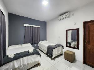 圣阿马鲁Eco House Gaivota - Cond Ville Portal das Dunas的一间卧室配有两张床和镜子
