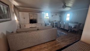a living room with a couch and a dining room at Nature's View - Dana Bay in Mossel Bay
