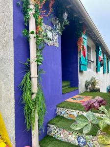 a purple house with plants on the side of it at Wonderland21 - B&B - Séjour féerique à 7 min Disneyland Paris in Saint-Germain-sur-Morin