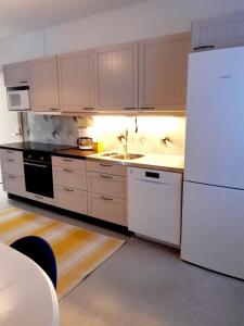 a kitchen with white appliances and a white refrigerator at Rauhallinen kahden makuuhuoneen asunto Iittalassa junaradan vieressä in Hämeenlinna