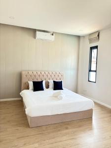 a bedroom with a large bed with white sheets and blue pillows at Dream pool villa 5 in Jomtien Beach +15 photos