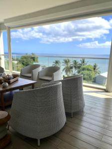 a room with chairs and a table and a view of the ocean at Salineo II Penthouse in Tamarin +47 photos