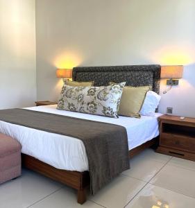 a bedroom with a large bed with pillows on it at Salineo II Penthouse in Tamarin
