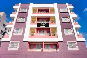 辛加瓦迪Super Collection O Uptown Hinjewadi的一座高大的紫色建筑,上面有标志