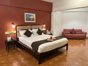 Un dormitorio con una cama grande y un sofá. en Konkan Crown Resort & Club, en Sawantwadi 54 fotos más