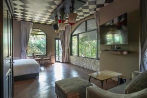 a bedroom with a bed and a living room at Bangkok Oasis Hotel in Bangkok
