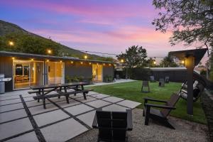 マリブにあるMalibu Beach House by Stay Awhile Villasの夜間のピクニックテーブルと椅子付きの裏庭
