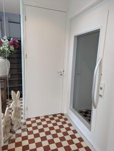 een kamer met een schuifdeur en een geruite vloer bij Mijn appartement met sauna en lift in Voerendaal