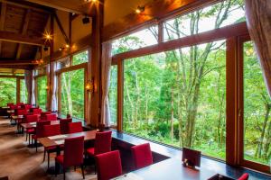 a dining room with red chairs and tables and large windows at Wan Wan Paradise Takayama in Takayama