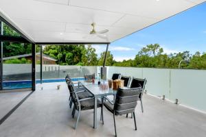 a dining room with a table and chairs on a patio at Belle Escapes Bluewater Breeze in Trinity Beach