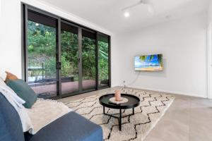 a living room with a blue couch and a table at Belle Escapes Bluewater Breeze in Trinity Beach