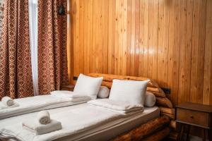 two beds sitting in a room with wooden walls at Hotel Piano Kvareli in Kvareli +120 photos