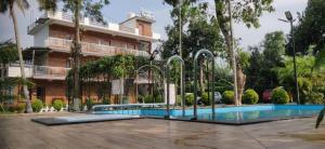 a swimming pool in front of a building at DOLPHIN ENCLAVE SERVICE STUDIO APARTMENTS in Kalpetta