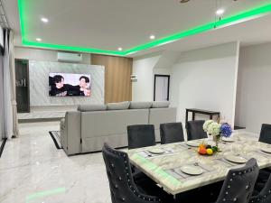 a dining room with a table and chairs and a tv at Dream pool villa 5 in Jomtien Beach