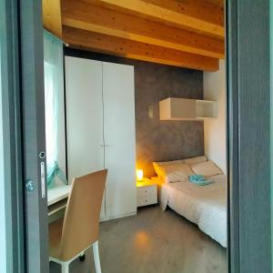 a bedroom with a bed and a desk with a chair at Residenza stella marina in Focene