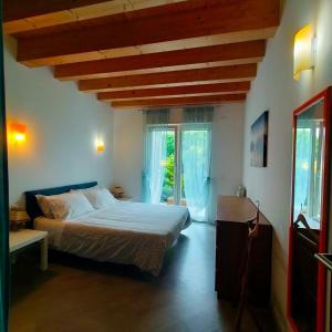 a bedroom with a bed and a large window at Residenza stella marina in Focene