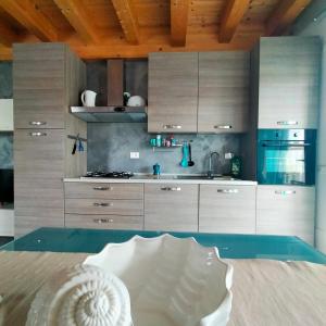 a kitchen with stainless steel appliances and wooden ceilings at Residenza stella marina in Focene
