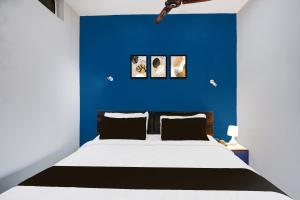a bedroom with a blue wall and a bed at Super Hotel O Noonmati Guwahati Formerly Hotel Sundari in Guwahati