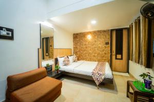a hotel room with a bed and a couch at The Sangam Hotel in Mahabaleshwar +34 photos